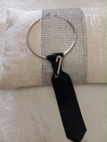 Cravattino nero con collana argentata e spilla gioiello